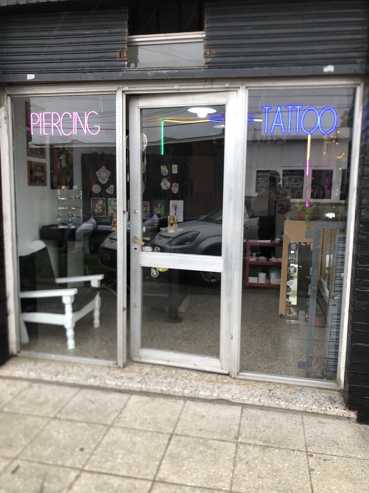 Fachada de Santos Tattoos de día con carteles de Piercing y Tattoo